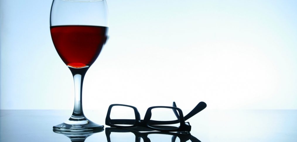 Glass of red wine and eye glasses