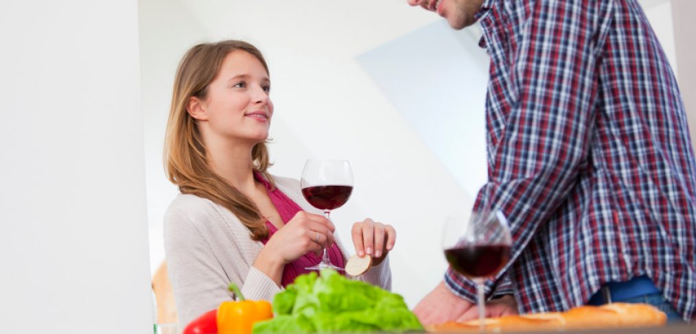 Couple cooking and drinking red wine for good health