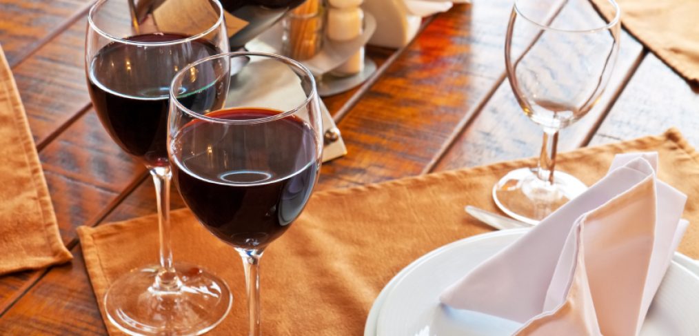 Cabernet filled wine glasses near food plates