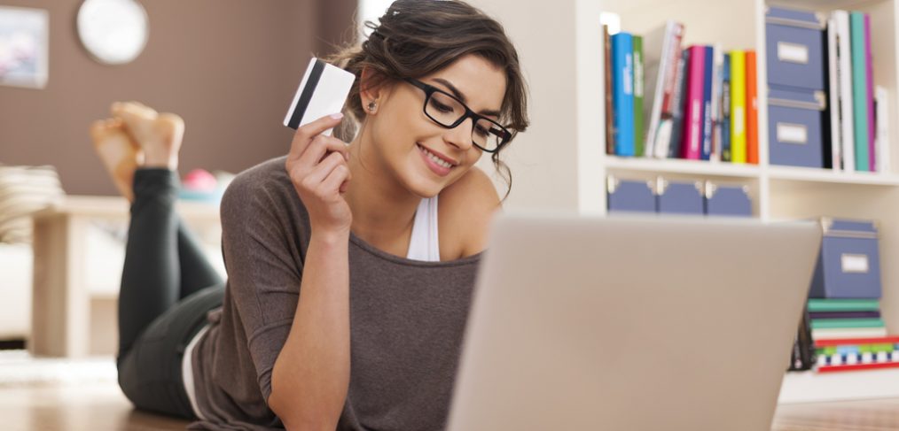 Woman with credit card in front of laptop