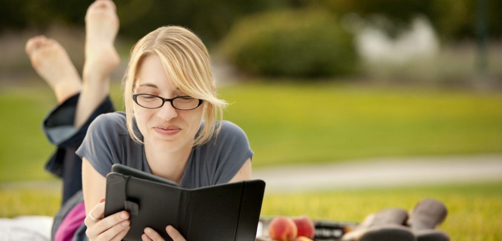 Woman reading a book in a park.