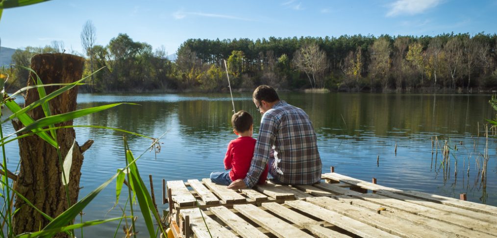 Family sitting beside lake