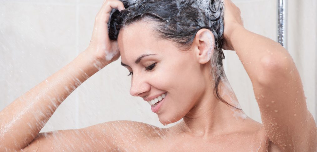 Woman taking a shower and shampooing her hair
