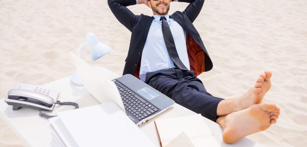 Man working on a laptop at beach