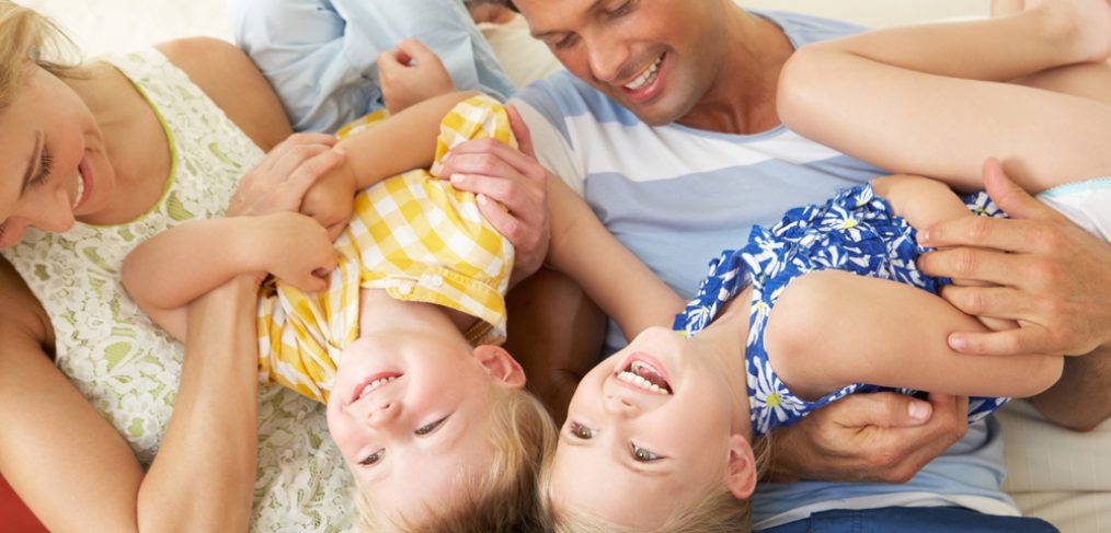 Family Playing On Sofa At Home