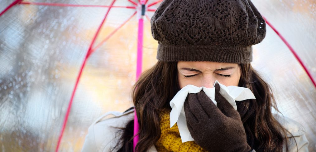 Woman sneezing into napkin