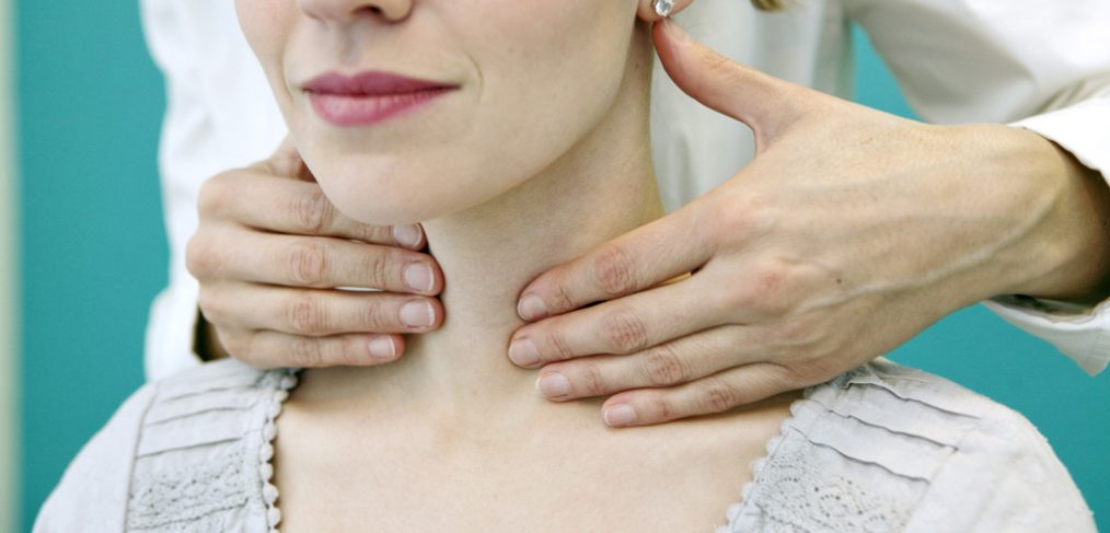 Doctor checking a patient for thyroids