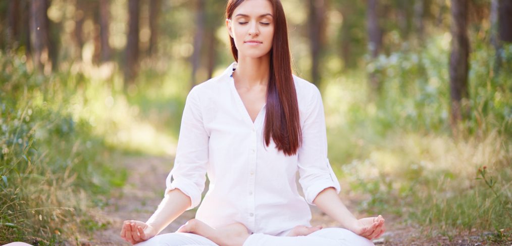 Woman meditating in the forest