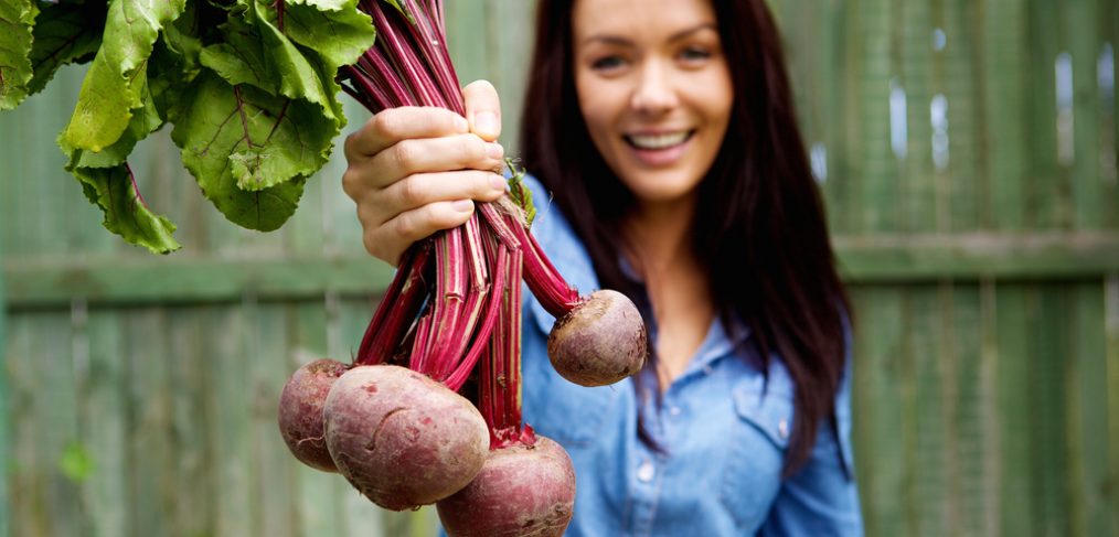 Woman holding up fresh beetroot