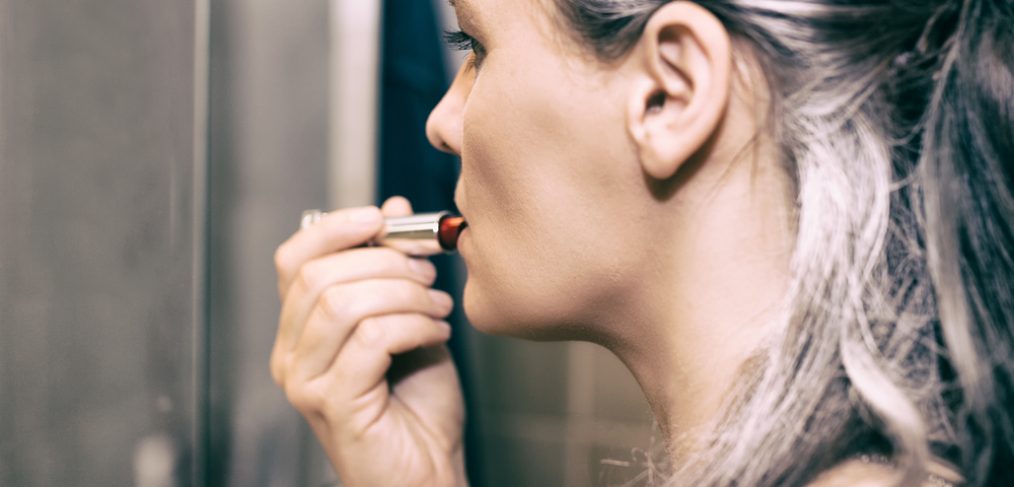 Woman applying lipstick