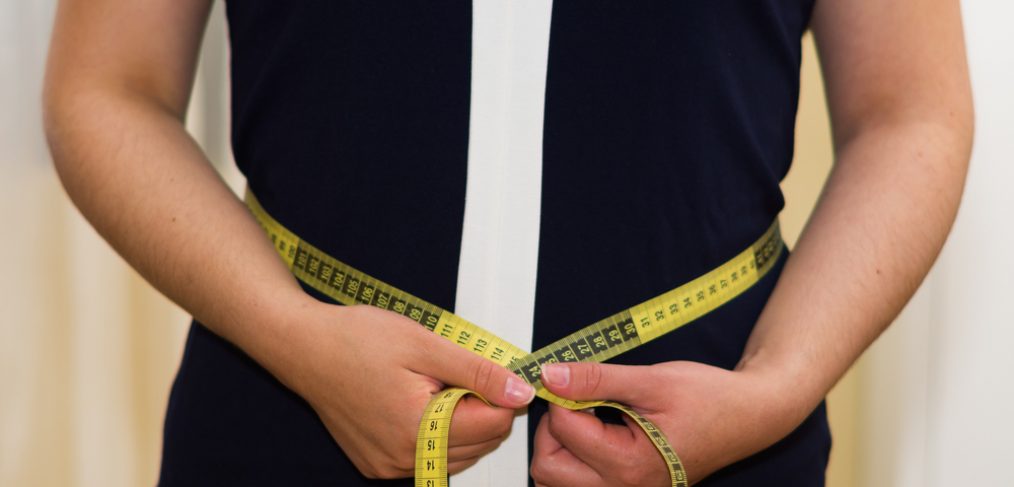 Woman measuring her dress size