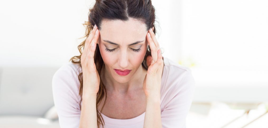 Woman holding head in pain