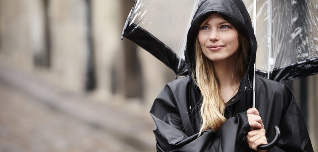 Woman shielding herself from the rain with umbrella