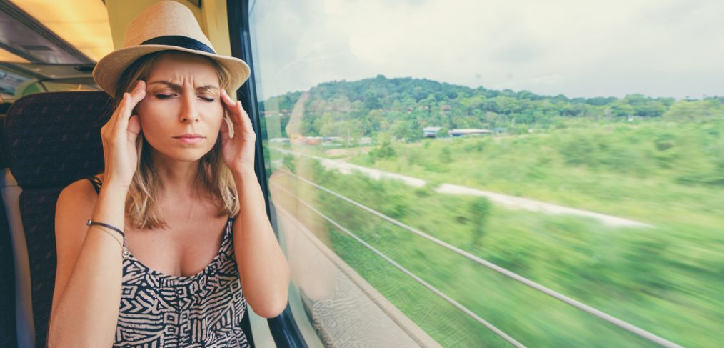 Woman holding her head in the train