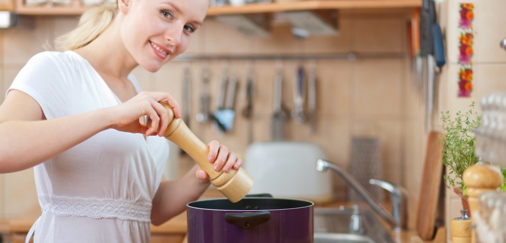 Woman adding salt to cooking