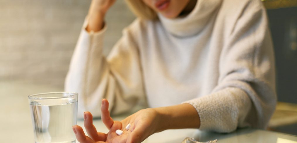 Unhappy woman taking pills