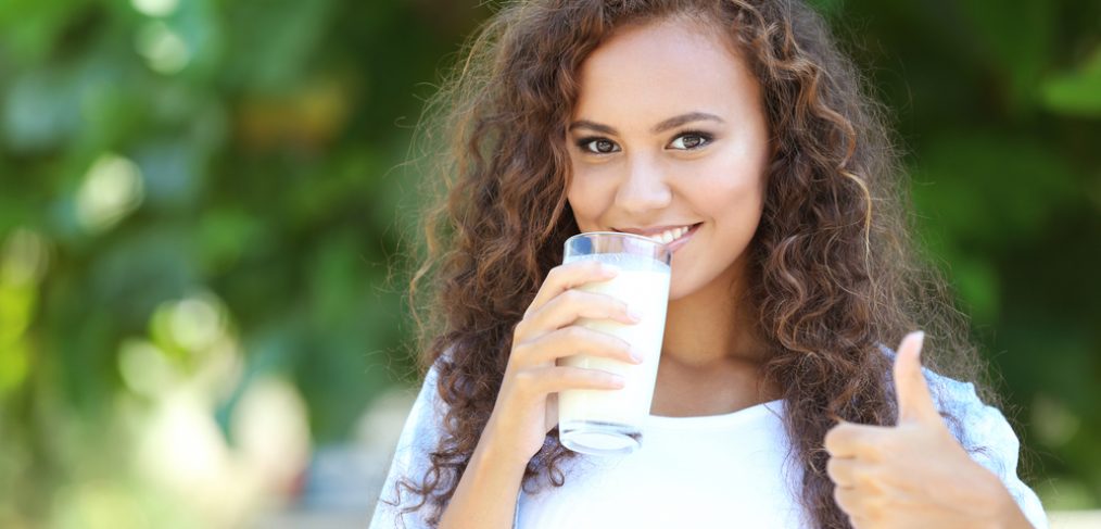 Woman drinking milk outdoors