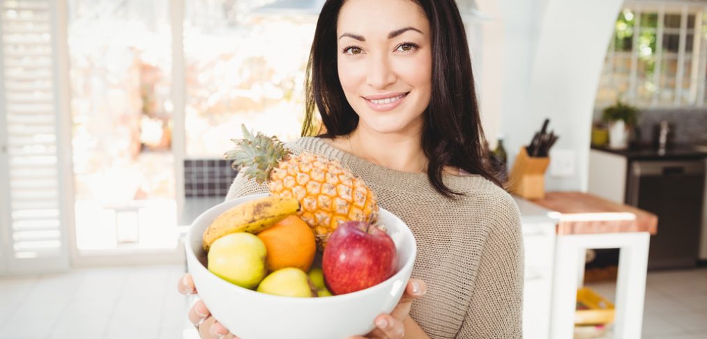 Woman holding a basket of fresh fruits