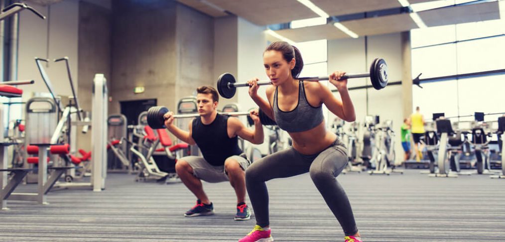 Couple lifting weights in the gym