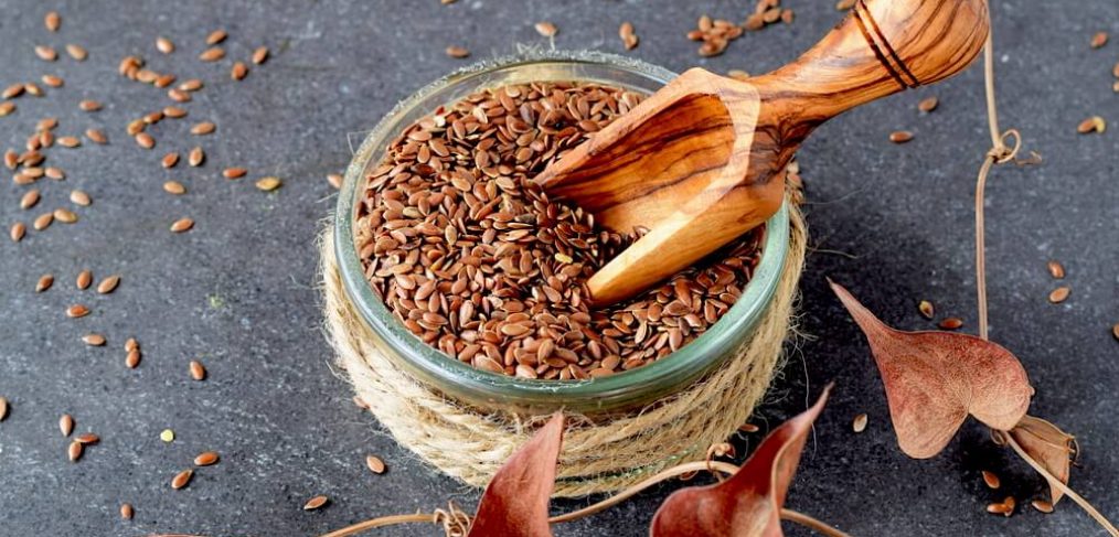 Small jar of flax seeds on grey stone table