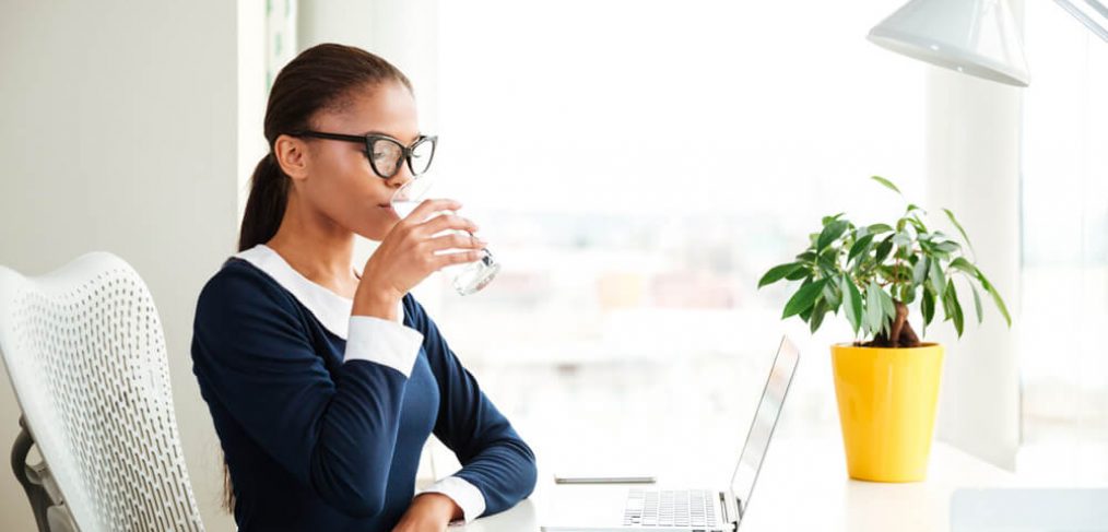 Woman drinking water at her work desk