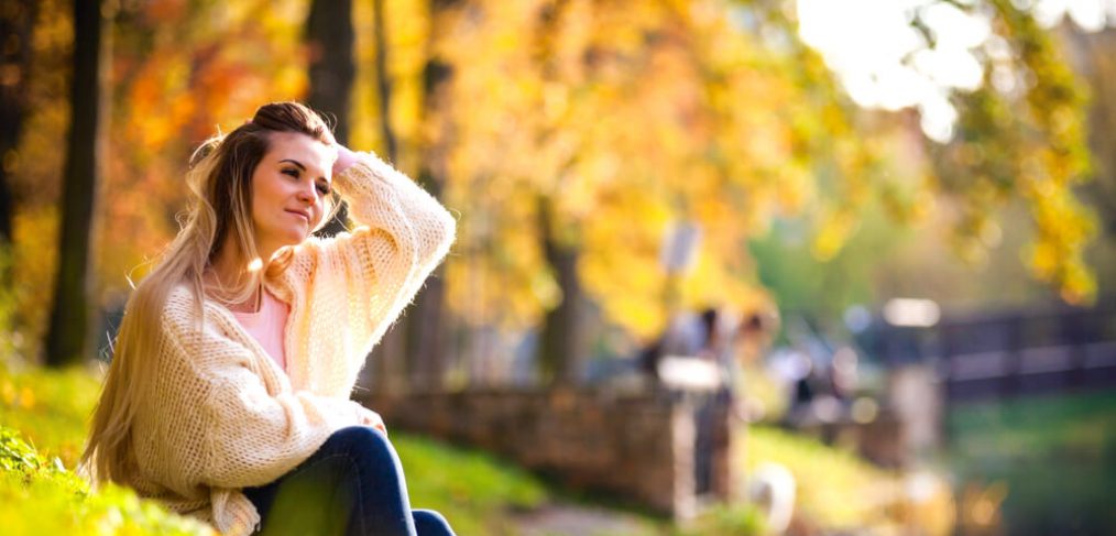 Relaxed woman sitting on the bank of river