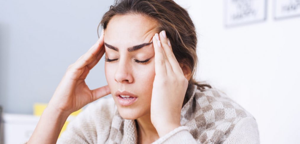 Woman massaging her temples due to a headache