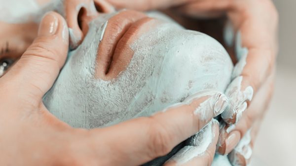 Closeup of woman enjoying facial mask treatment