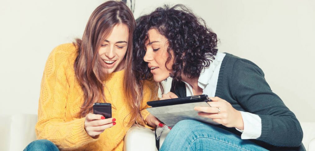 Friends laughing while using a tablet