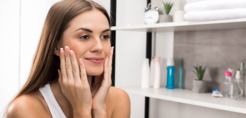 Smiling woman looking at herself in the mirror