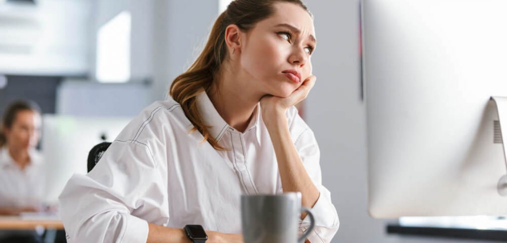 Woman looking stressed and bored at work